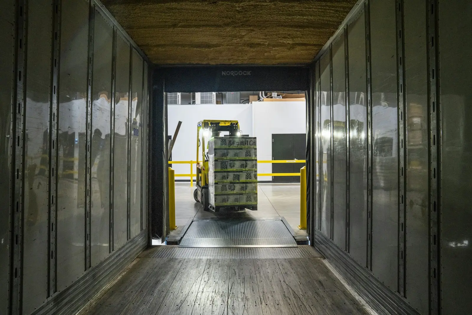 Yükleme rampasından tır dorsesine paletli yük taşıyan forklift, dorse içinden görünüm