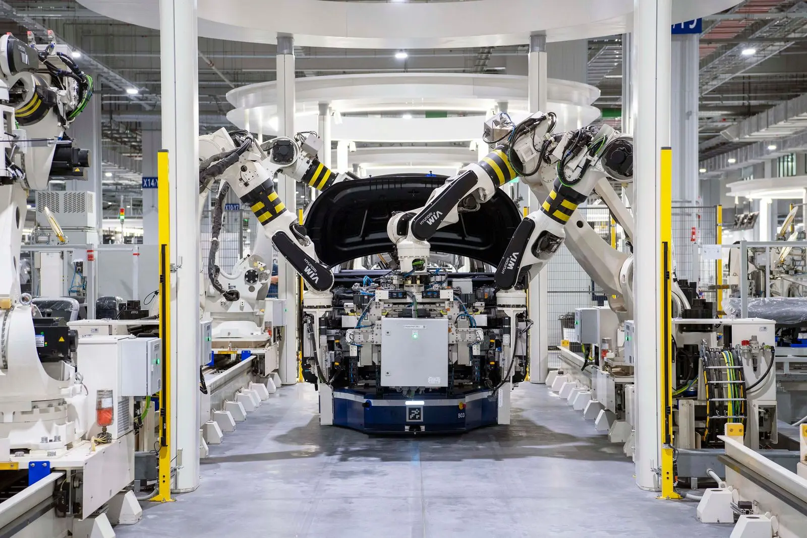 Otomotiv montaj hattında araç gövdesi üzerinde çalışan endüstriyel robot kolları